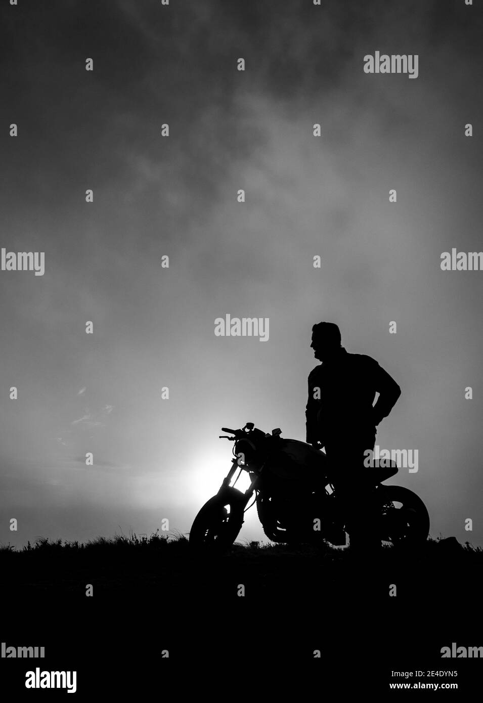 Motorbiker en la puesta de sol, Azores, Sao Miguel isla, silueta, blanco y negro, vertical. Foto de stock