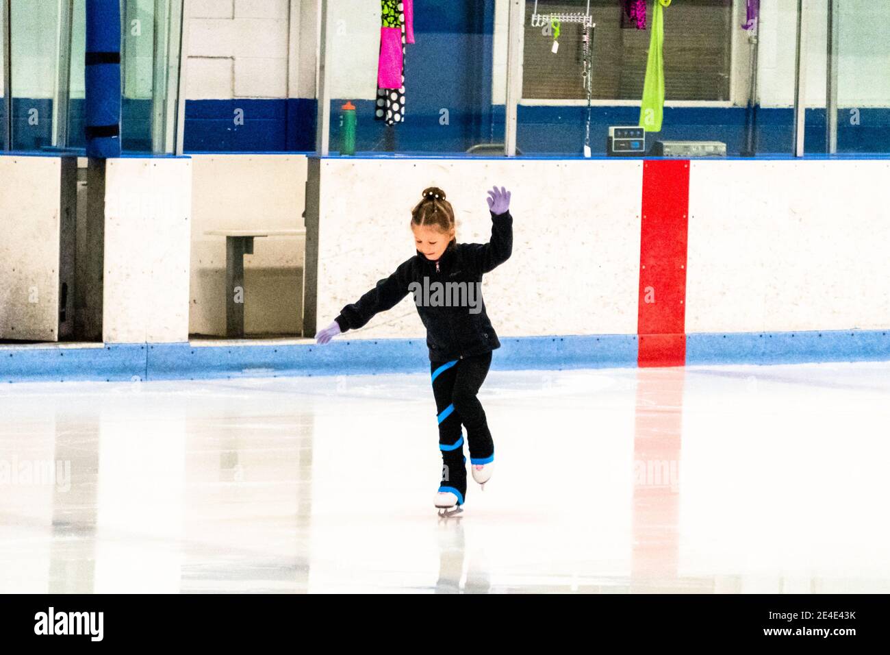 Niña practicando patinaje artístico en una pista de hielo cubierta  Fotografía de stock - Alamy