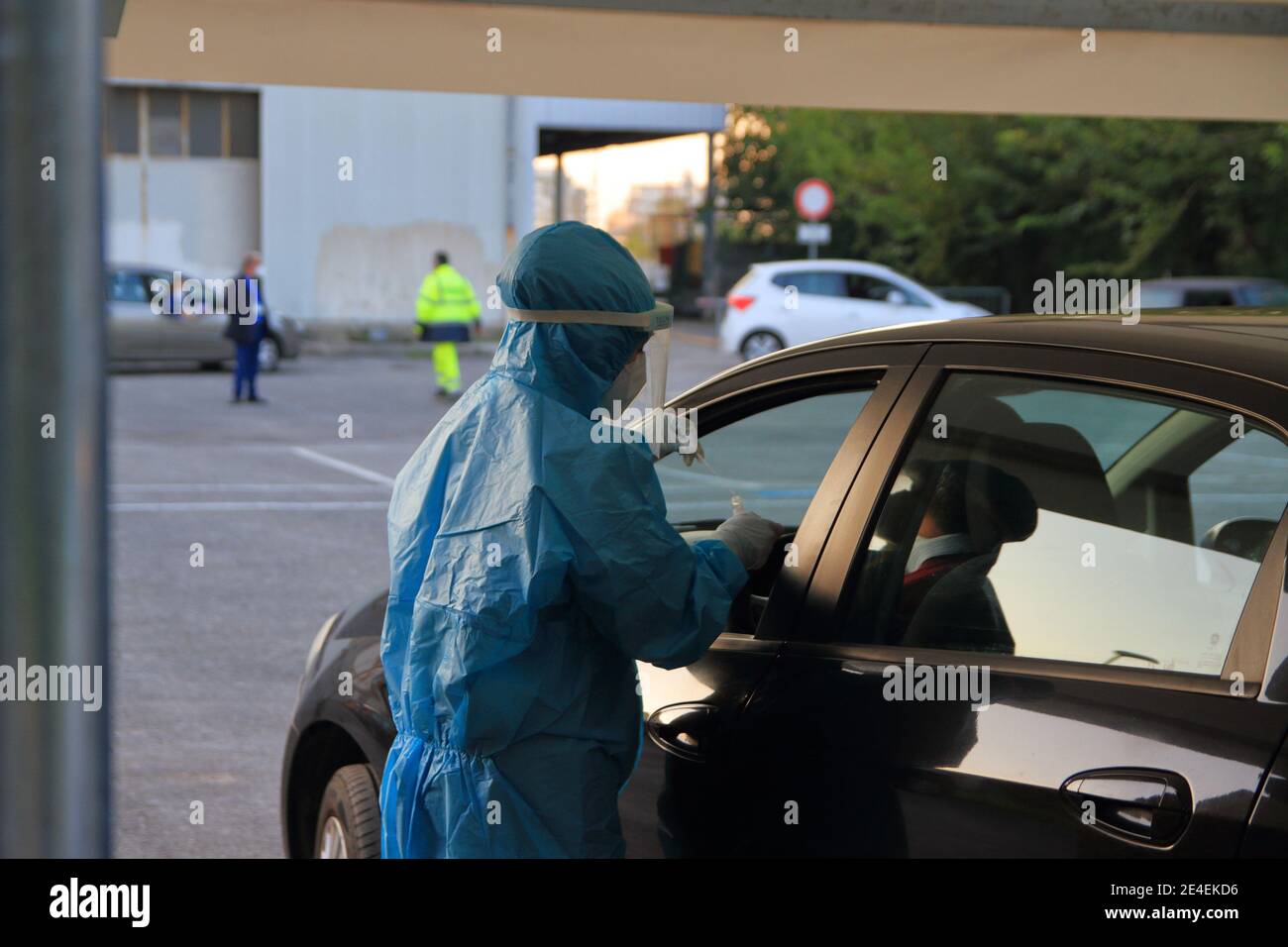 El médico con máscara y visera hace tamponar a la persona sentada en el auto  para emergencias covid-19 Fotografía de stock - Alamy