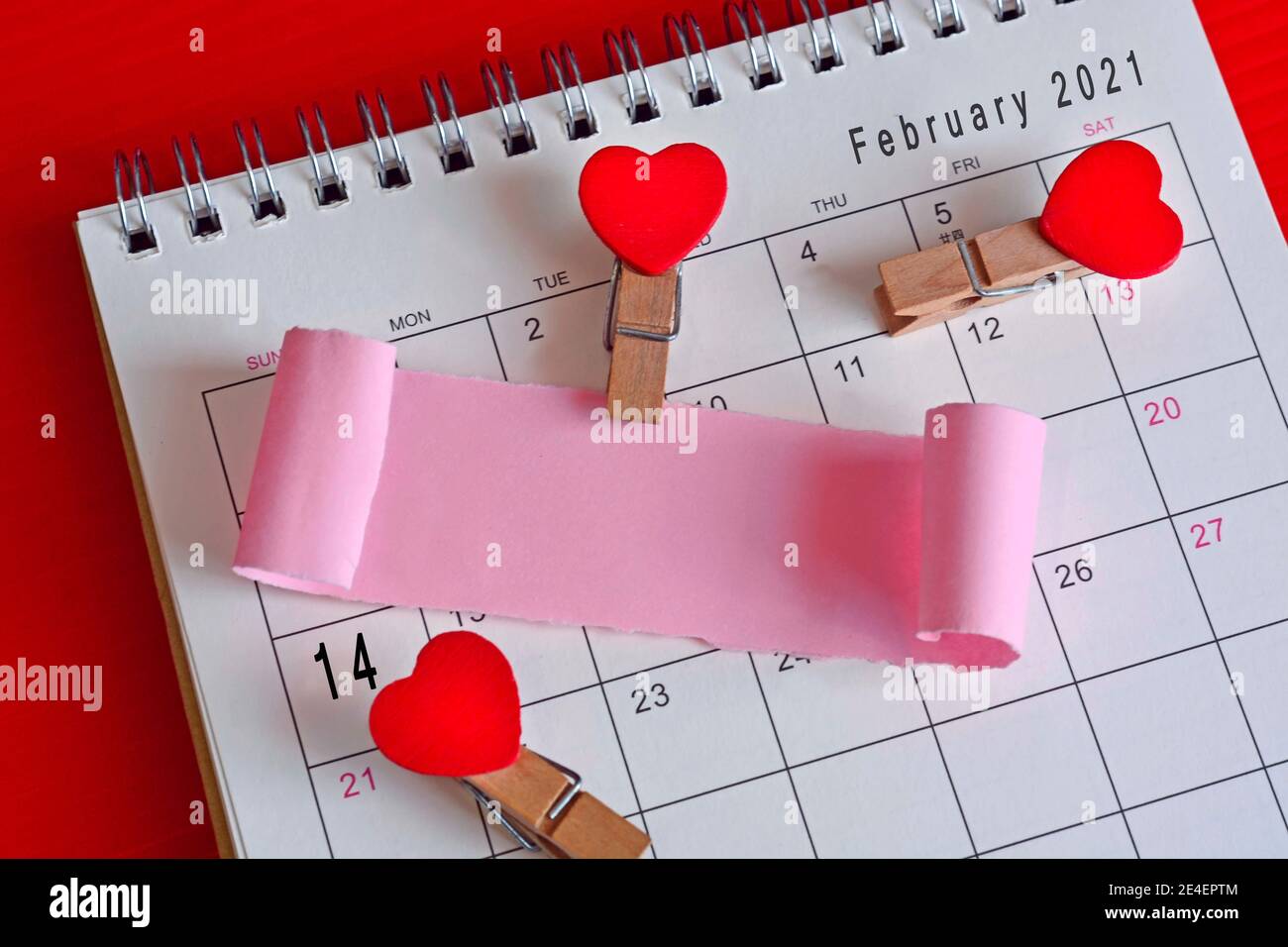 Papel roto en el calendario de febrero de 2021 con fondo rojo. Feliz día de San Valentín Foto de stock