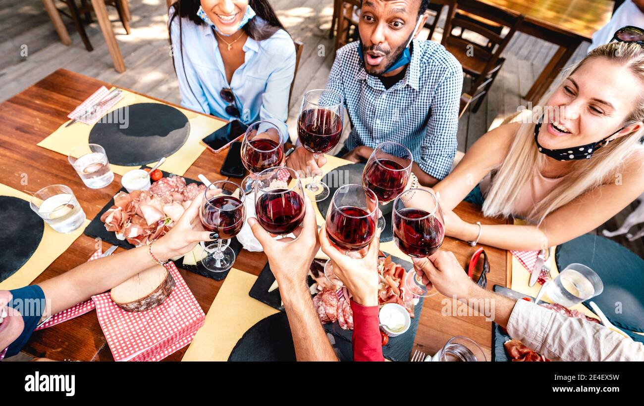 Amigos bebiendo vino tinto en el bar del restaurante con cara abierta  Máscara - Nuevo concepto de estilo de vida normal con gente feliz teniendo  diversión juntos Fotografía de stock - Alamy
