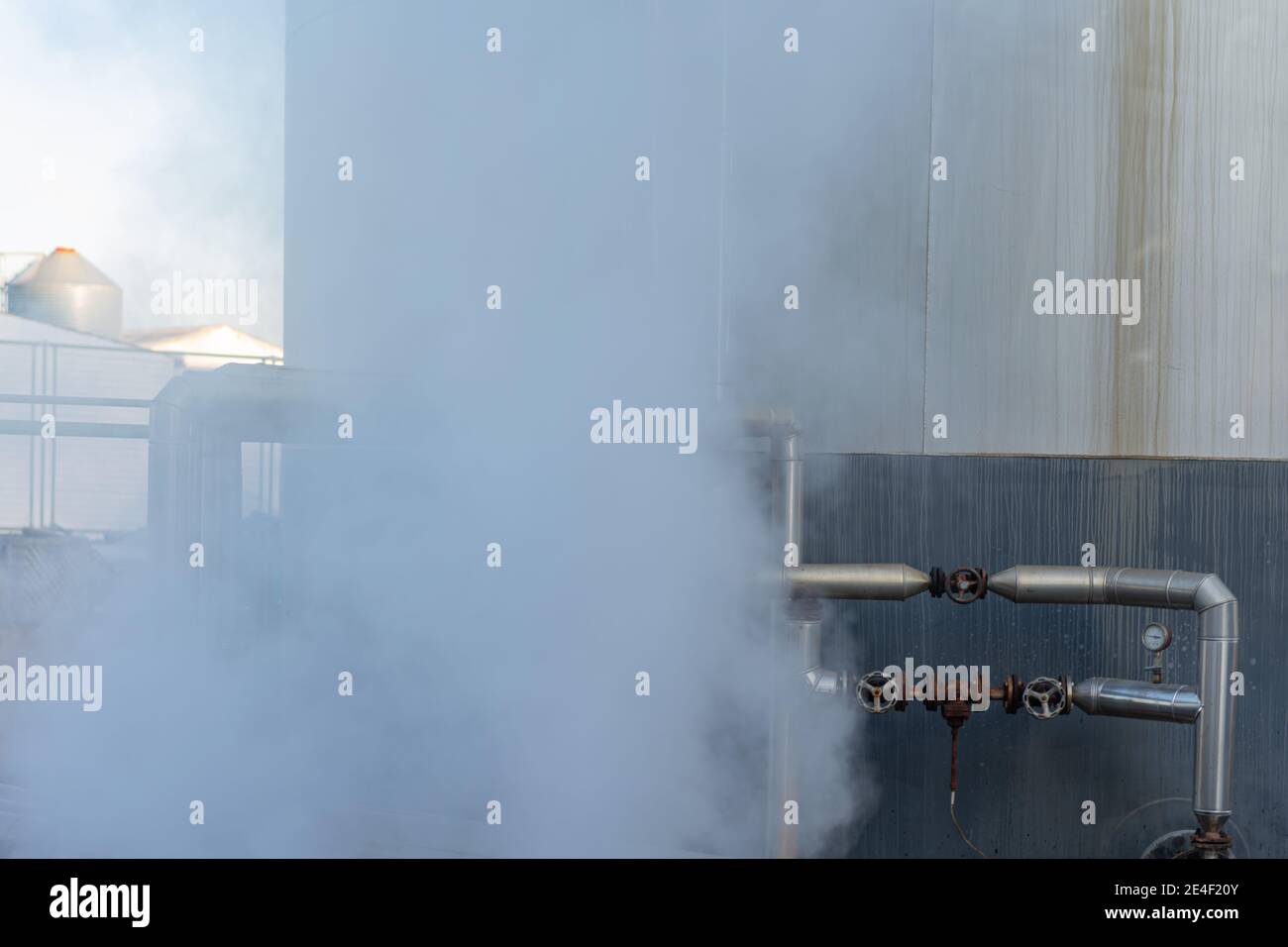 Tubos para líquidos a alta temperatura junto a un tanque y que deshacen el  vapor Fotografía de stock - Alamy