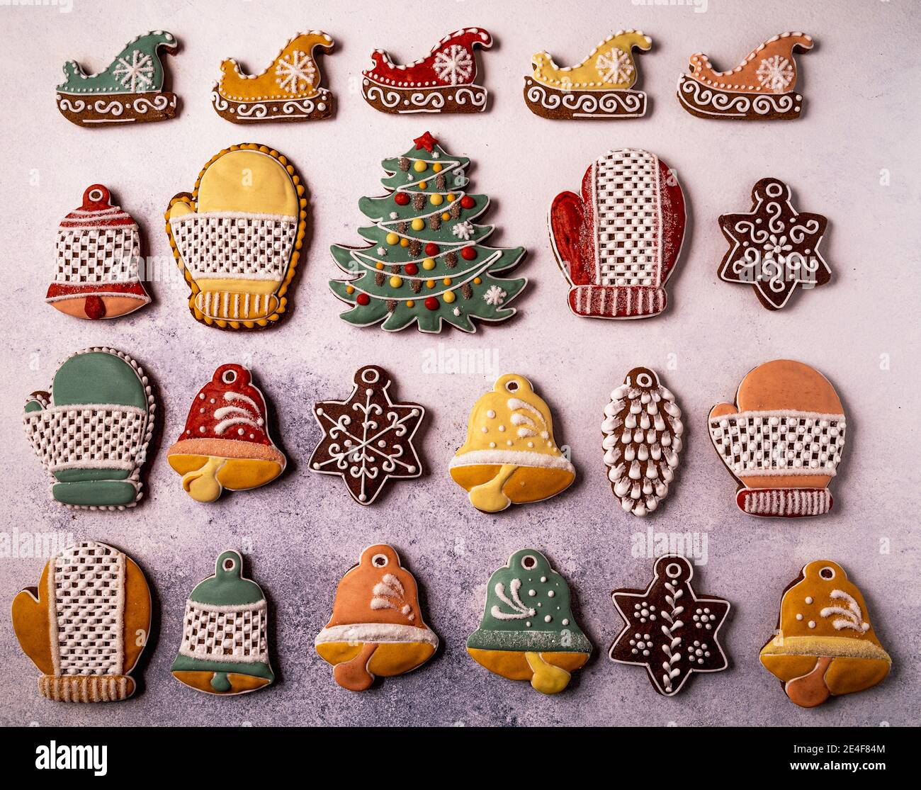 Galletas caseras de Navidad de pan de jengibre sobre fondo gris concreto plano, estilo de mollamiento. Copo de nieve, picea, estrella, trineo, conos, cono estrella campana Foto de stock