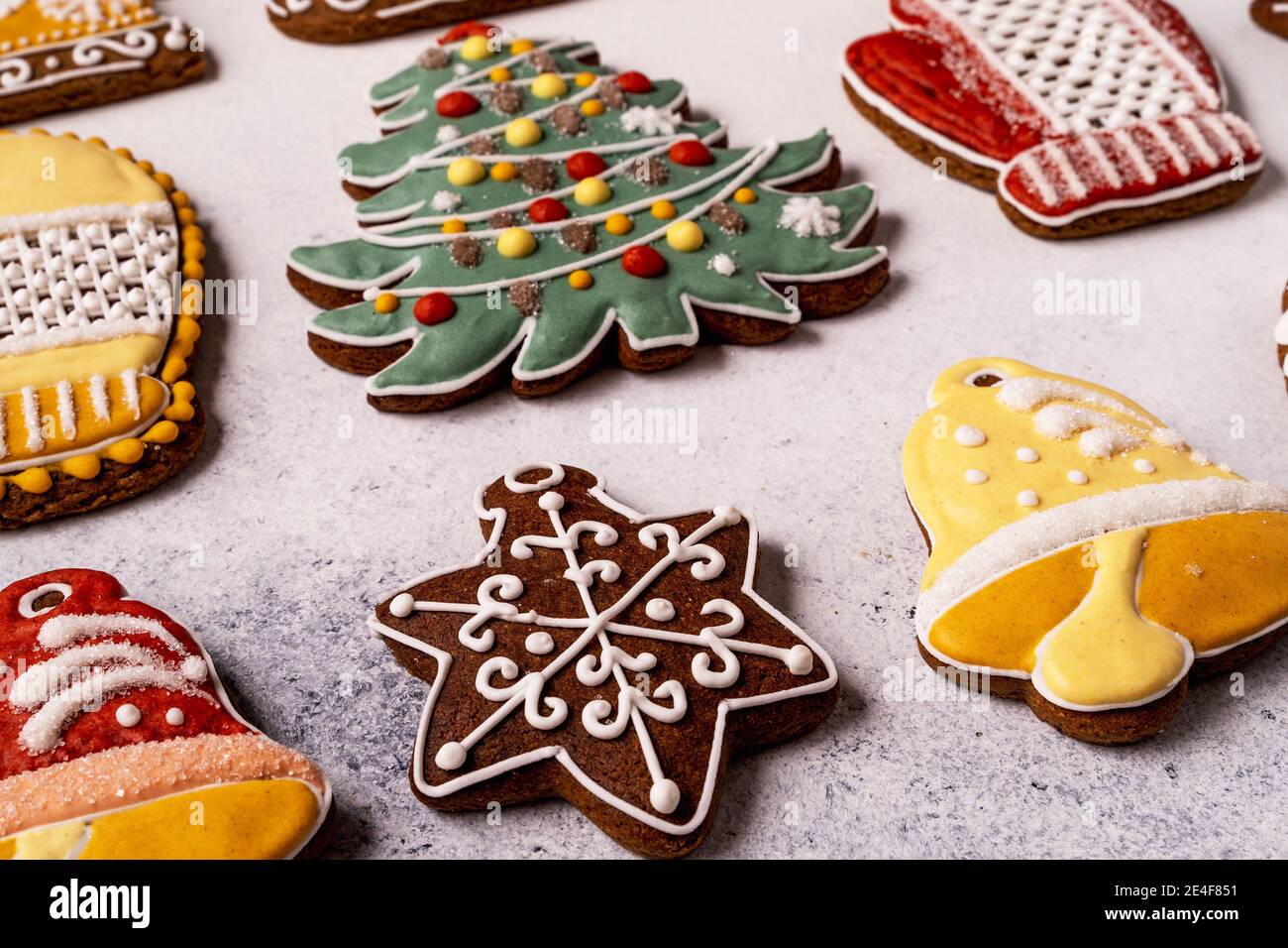 Primer plano Navidad Gingerbread sobre fondo de hormigón gris. Copo de nieve, picea, estrella, trineo, conos, cono, forma de campana de estrella Foto de stock