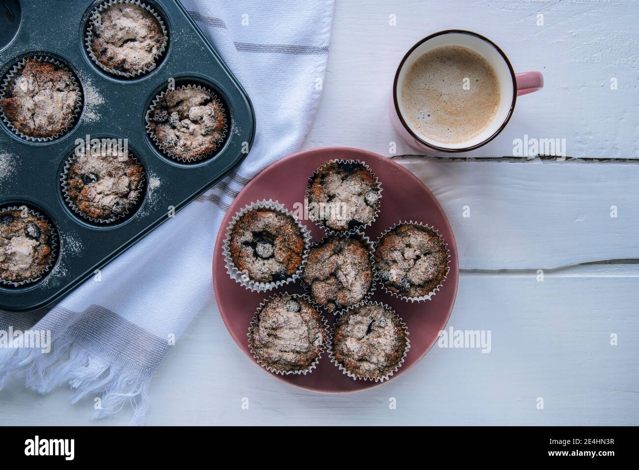 Muffins sanos de la harina de avena en el plato rosado y taza del