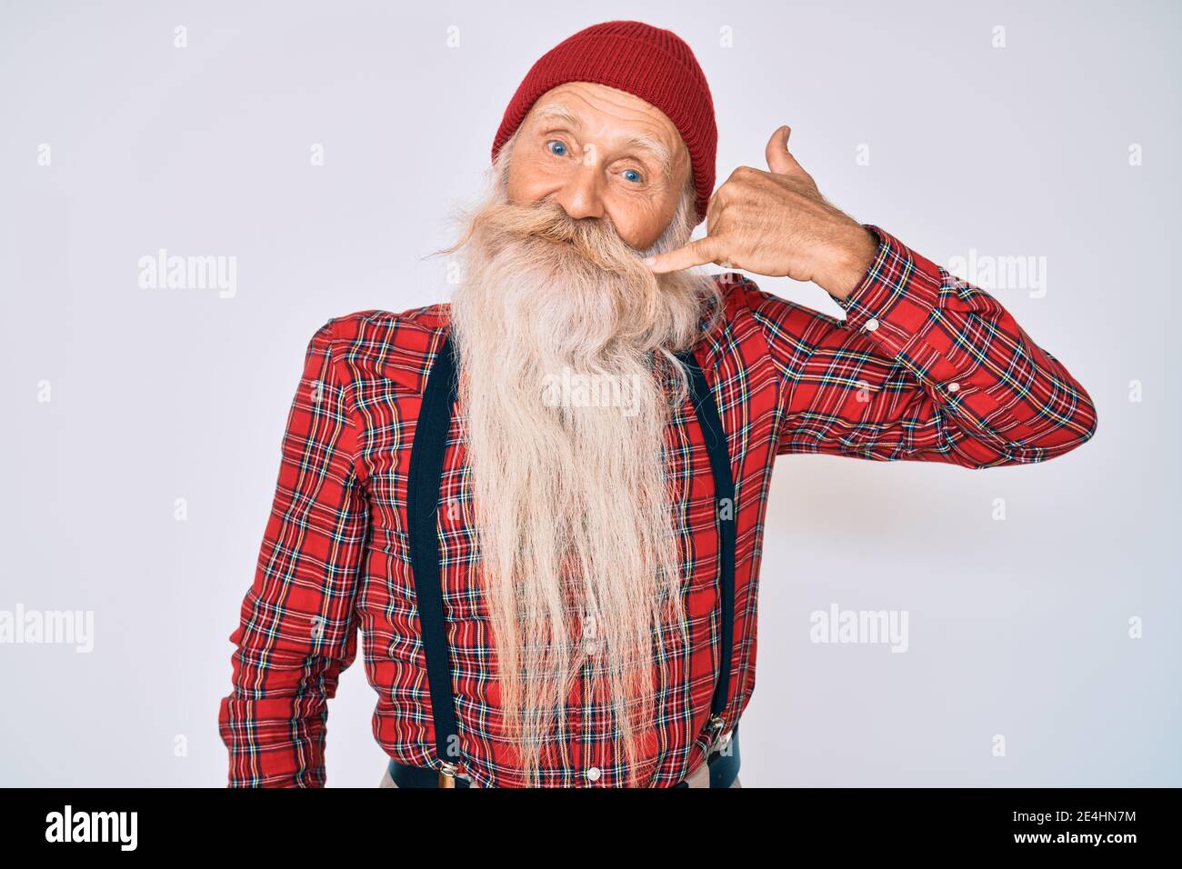 Viejo anciano con pelo gris y barba larga hipster look con gorro de lana  sonriendo haciendo gesto de teléfono con la mano y los dedos como hablar en  el Fotografía de stock -