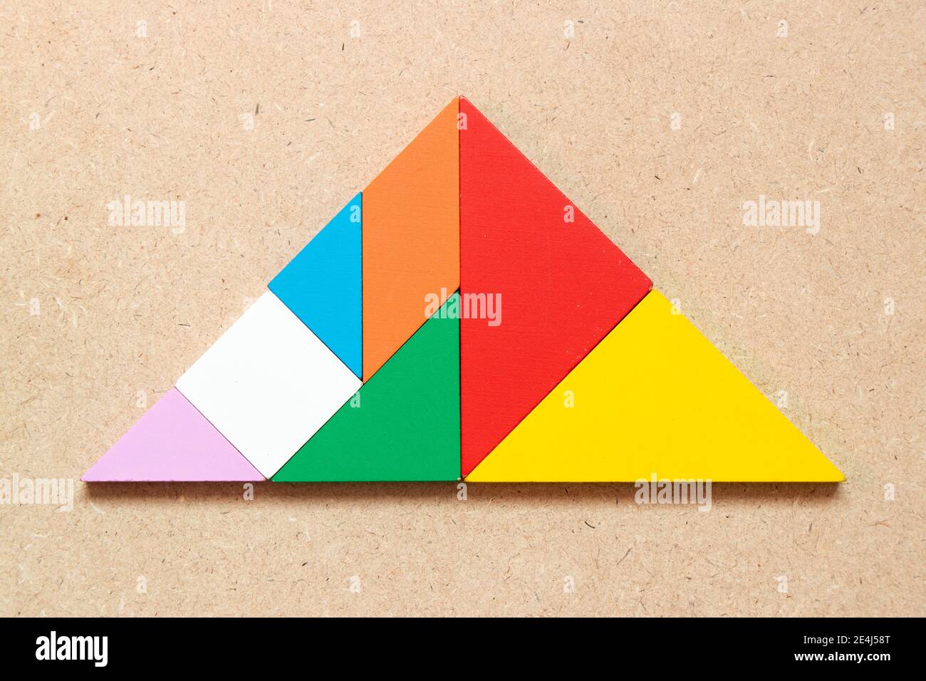 Rompecabezas de color tangram en forma de triángulo sobre fondo de madera  Fotografía de stock - Alamy
