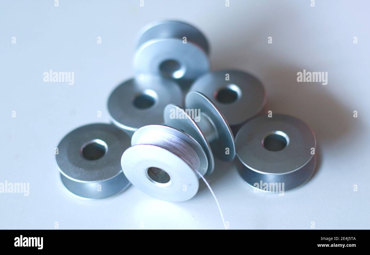 hilados de acero para máquina de coser, bobina para hilo y otras  herramientas o partes sobre fondo blanco Fotografía de stock - Alamy