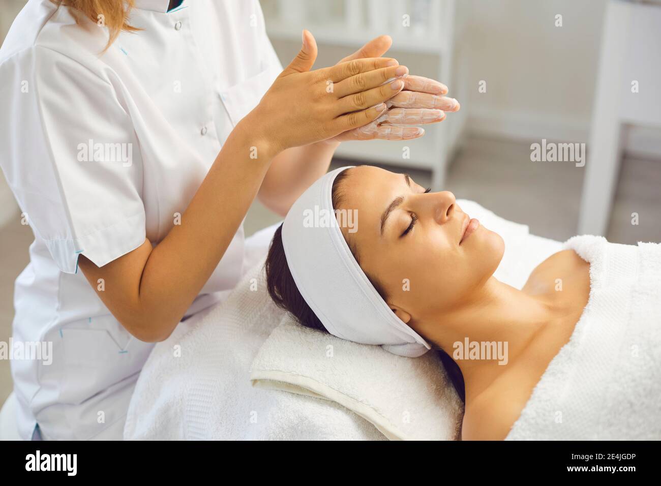 Mujer dermatólogo frotando crema hidratante para aplicar onvwomans cara después cuidado de la piel Foto de stock
