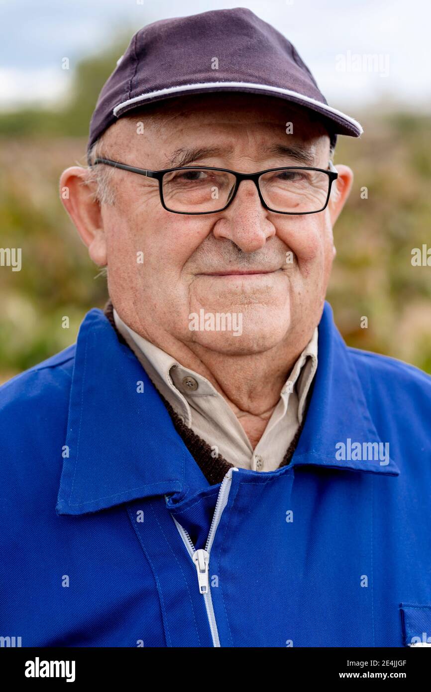 página reloj de repuesto Hombre mayor con gorra y anteojos contra granja de uva Fotografía de stock  - Alamy