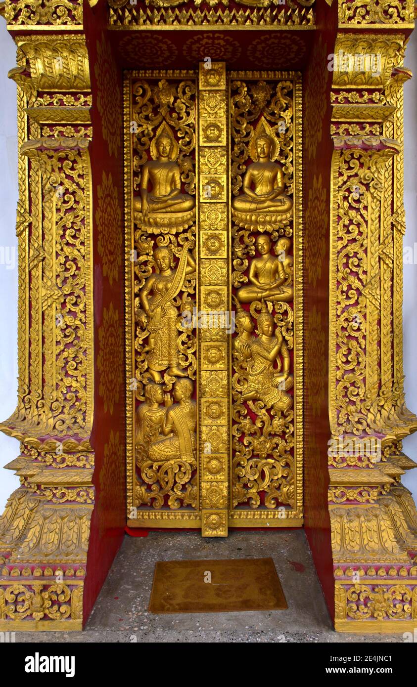 Portal de entrada con tallas doradas, criaturas mitológicas míticas y escenas de la vida de Buda, templo Wat Nong Sikhounmuang, Luang Foto de stock