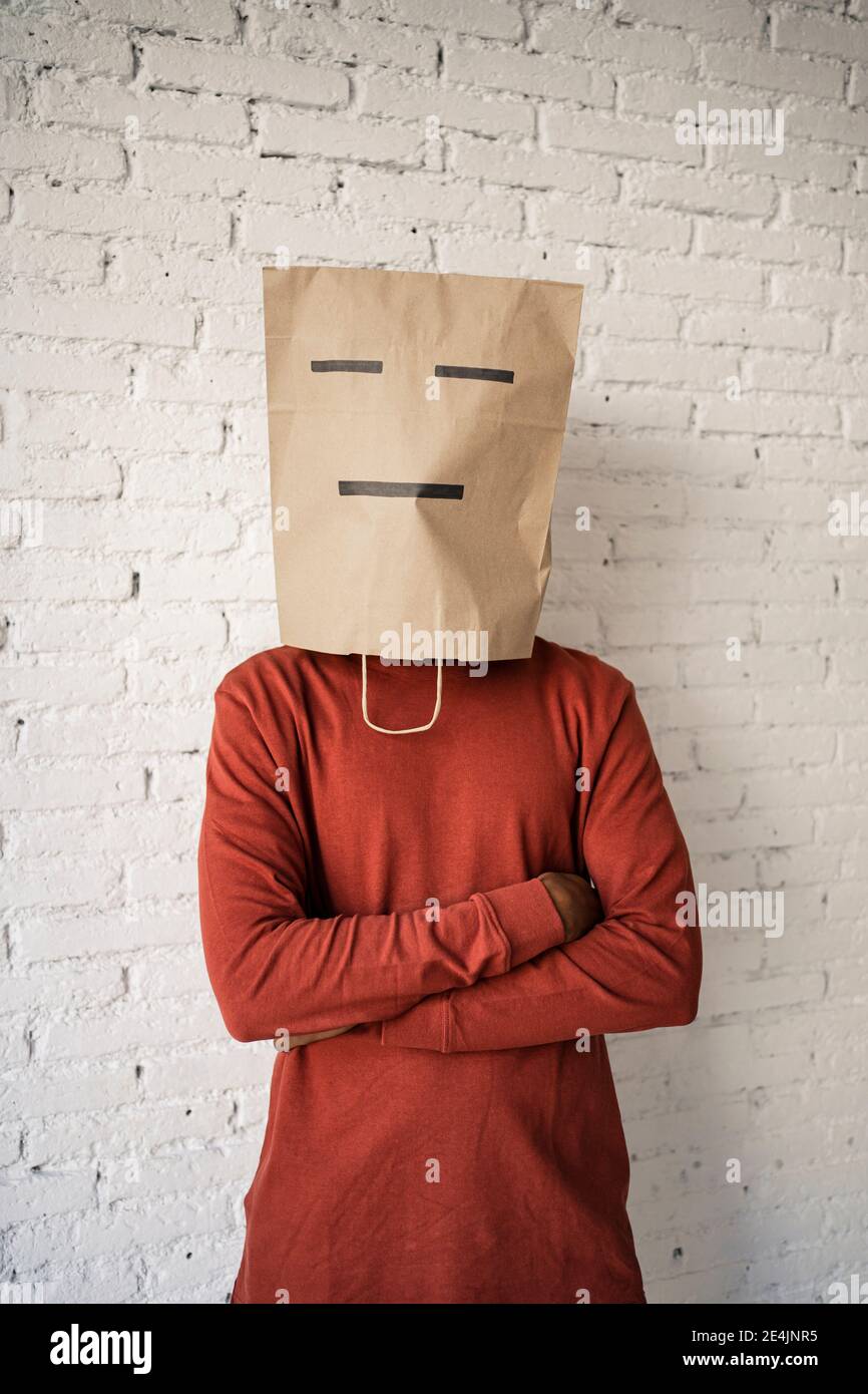 banco partido Republicano lápiz Hombre con bolsa de papel en la cara con los brazos cruzados pared de  ladrillo blanco Fotografía de stock - Alamy