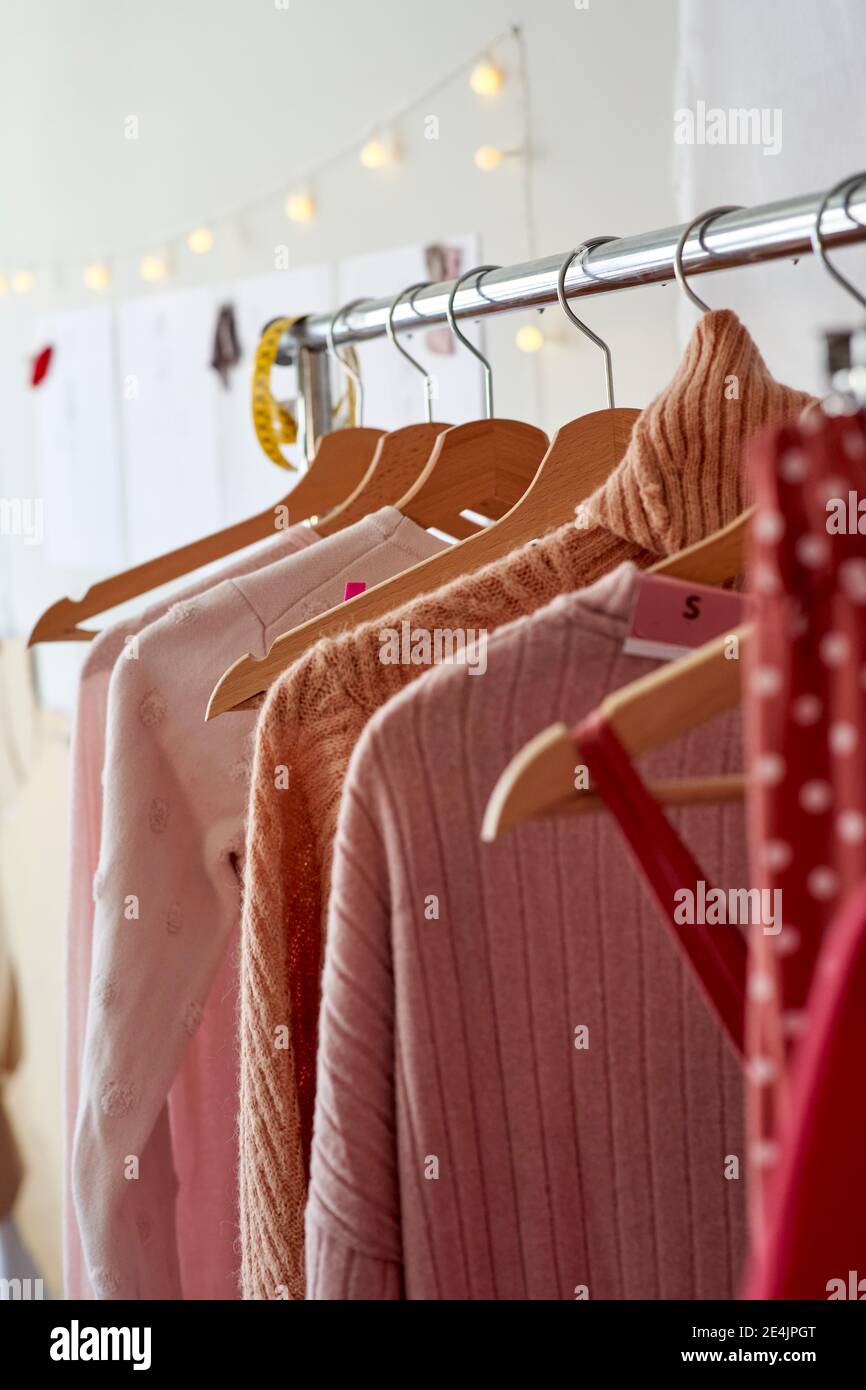 Estante de ropa con variación de ropa de mujer en el taller Foto de stock