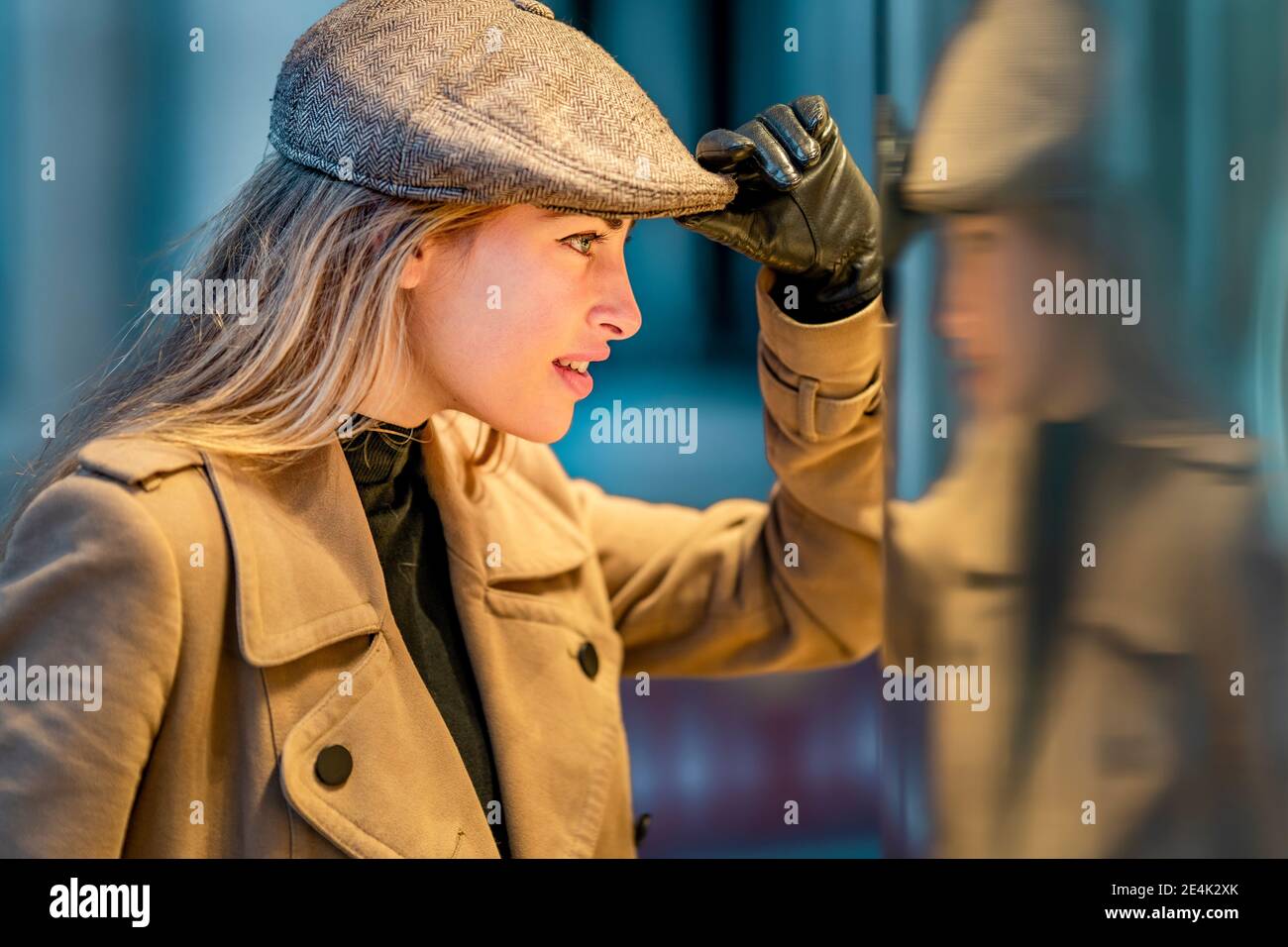 Hermosa mujer mirando en la pared de material de vidrio Foto de stock