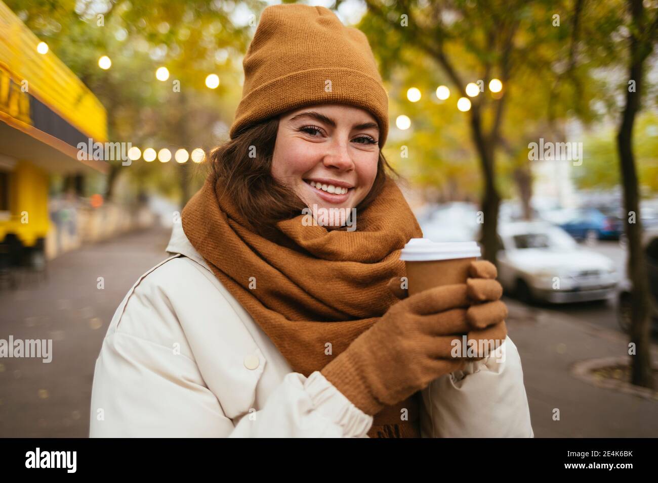 https://c8.alamy.com/compes/2e4k6bk/feliz-mujer-joven-en-sombrero-de-punto-con-taza-de-cafe-desechable-durante-el-invierno-2e4k6bk.jpg