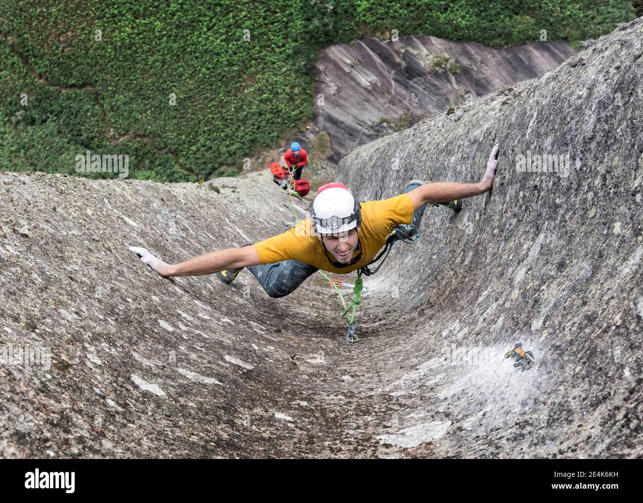 Macho escalador de roca desafiando pared escarpada de Pedra Baiana Foto de stock