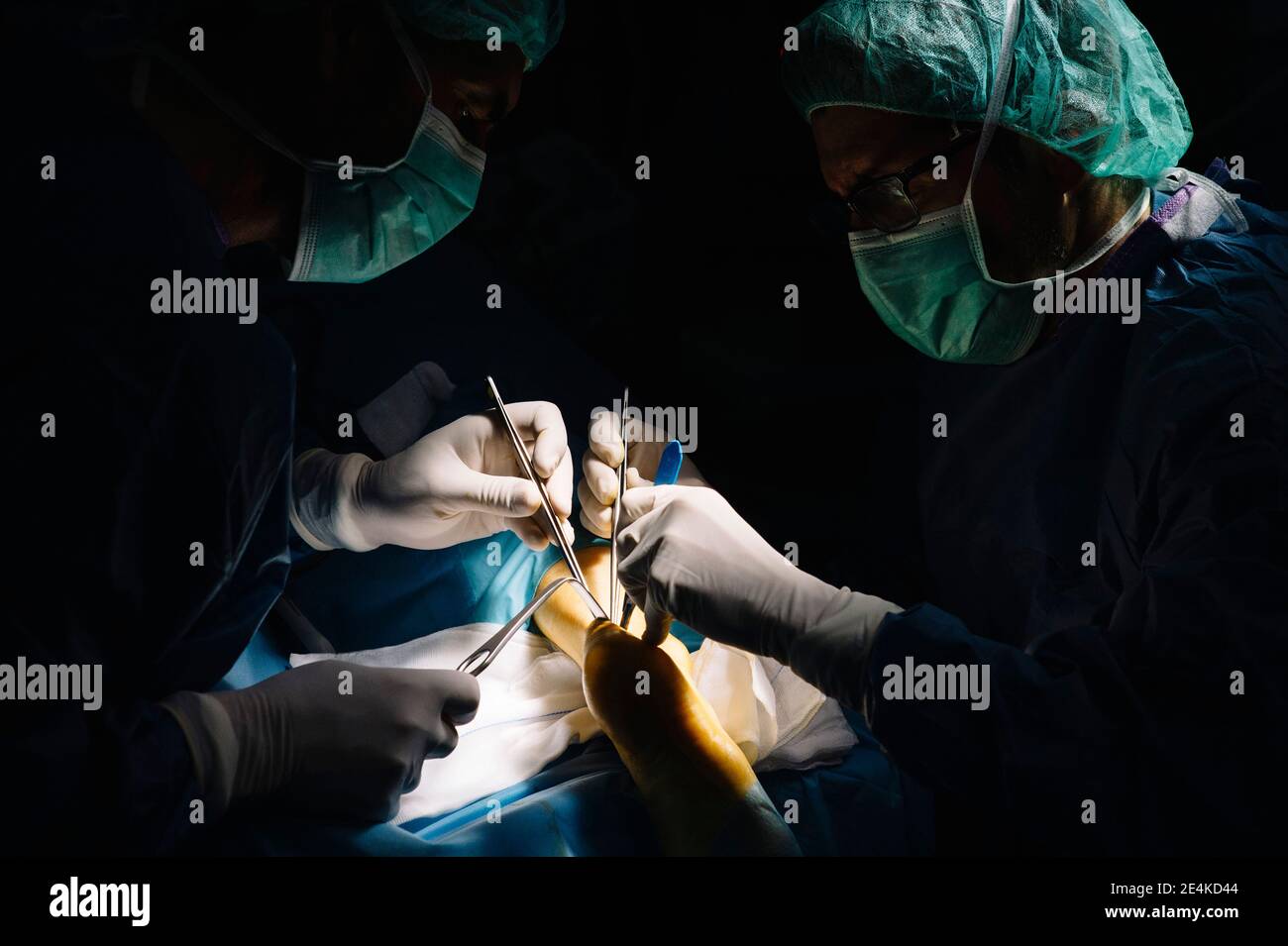 Cirujanos varones que realizan operaciones con tijeras en la sala de urgencias del hospital Foto de stock