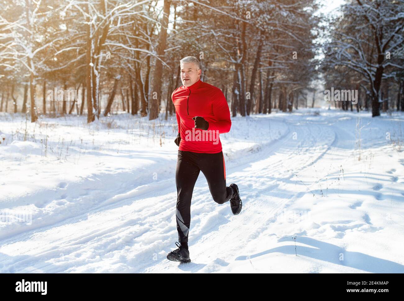 Hombre maduro atlético en jogging de ropa deportiva en el parque de invierno  nevado. Corredor senior sano al aire libre en clima frío Fotografía de  stock - Alamy