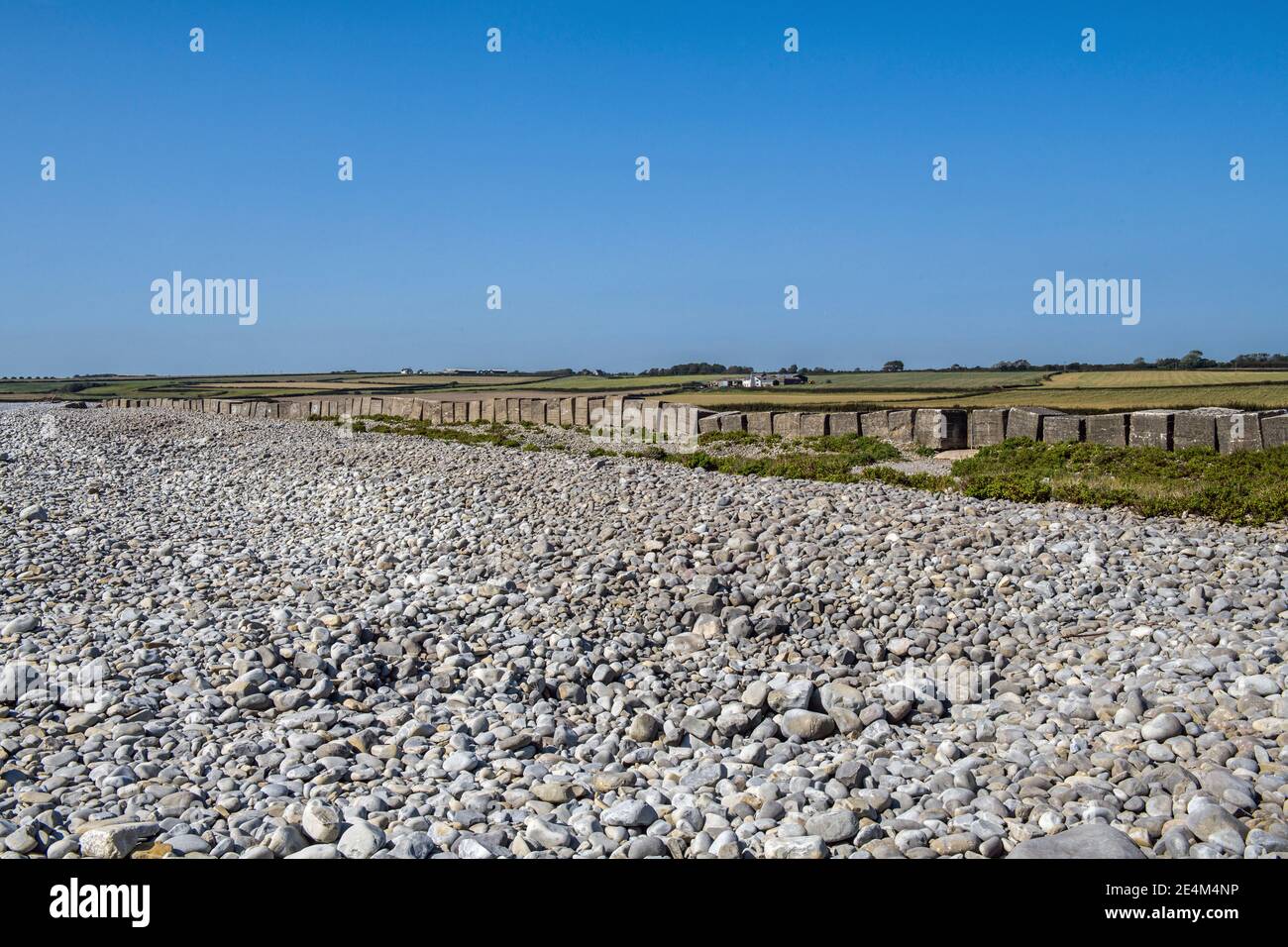 La playa de Aberthaw muestra guijarros y bloques antitanque en la Costa del Patrimonio de Glamourgan, Vale de Glamourgan Gales del Sur Foto de stock