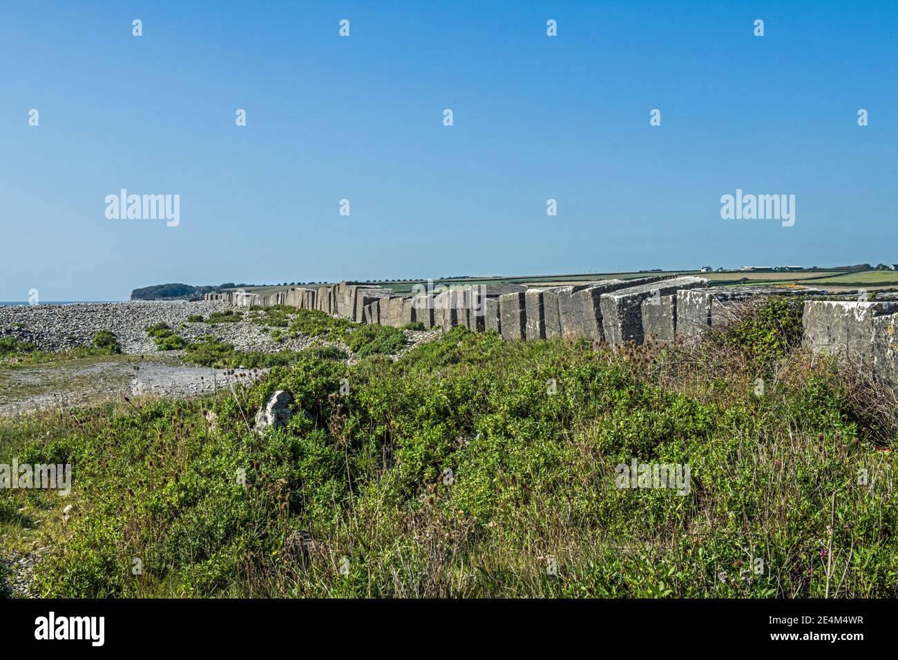 La playa de Aberthaw muestra guijarros y bloques antitanque en la Costa del Patrimonio de Glamourgan, Vale de Glamourgan Gales del Sur Foto de stock