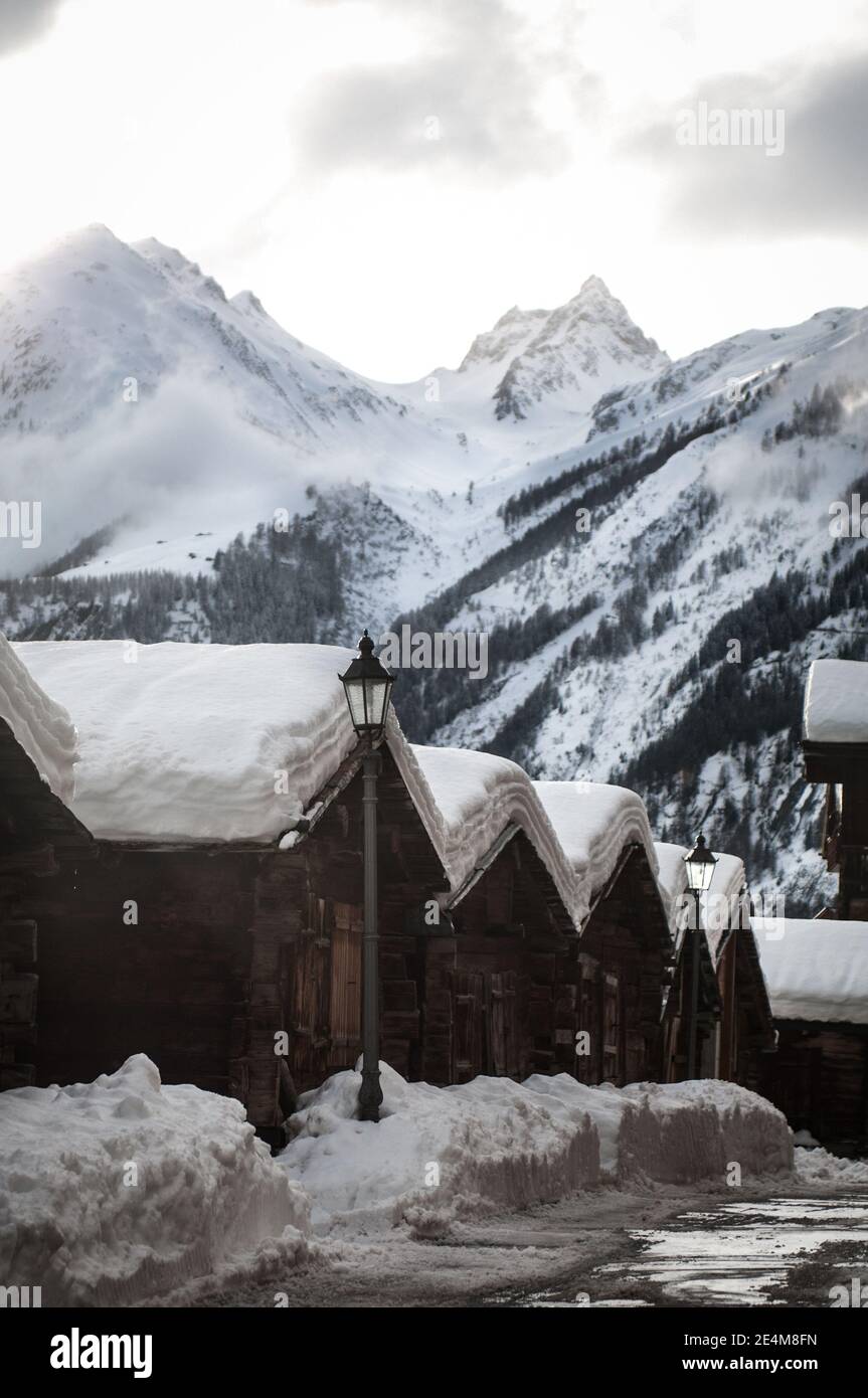 casas tradicionales de madera en un pueblo de montaña en los alpes suizos en invierno con techos cubiertos de nieve. Foto de alta calidad Foto de stock
