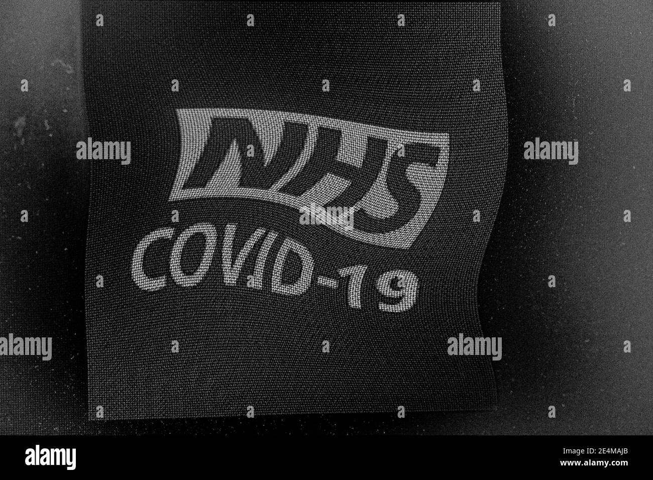 un primer plano del logotipo de rastreo de contactos de NHS COVID-19 distorsionado para monitorear la propagación de la pandemia de COVID-19 en Inglaterra y Gales. Foto de stock