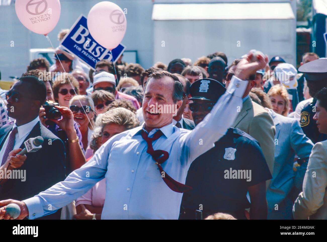 Detroit, Michigan - George H. W. Bush visita la Feria del Estado de Michigan mientras hace campaña por el presidente. Él está lanzando bolas para tratar de golpear a un payaso en un tanque de agua. Foto de stock