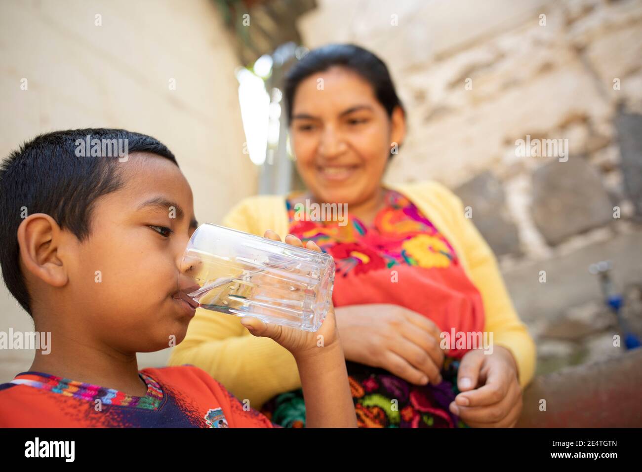Un niño bebe un vaso de agua limpia en San Juan la Laguna, Guatemala  Fotografía de stock - Alamy