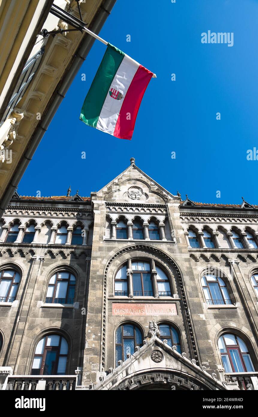 Bandera húngara contra el cielo azul y fachada neogótica en Buda Castillo de Budapest Foto de stock