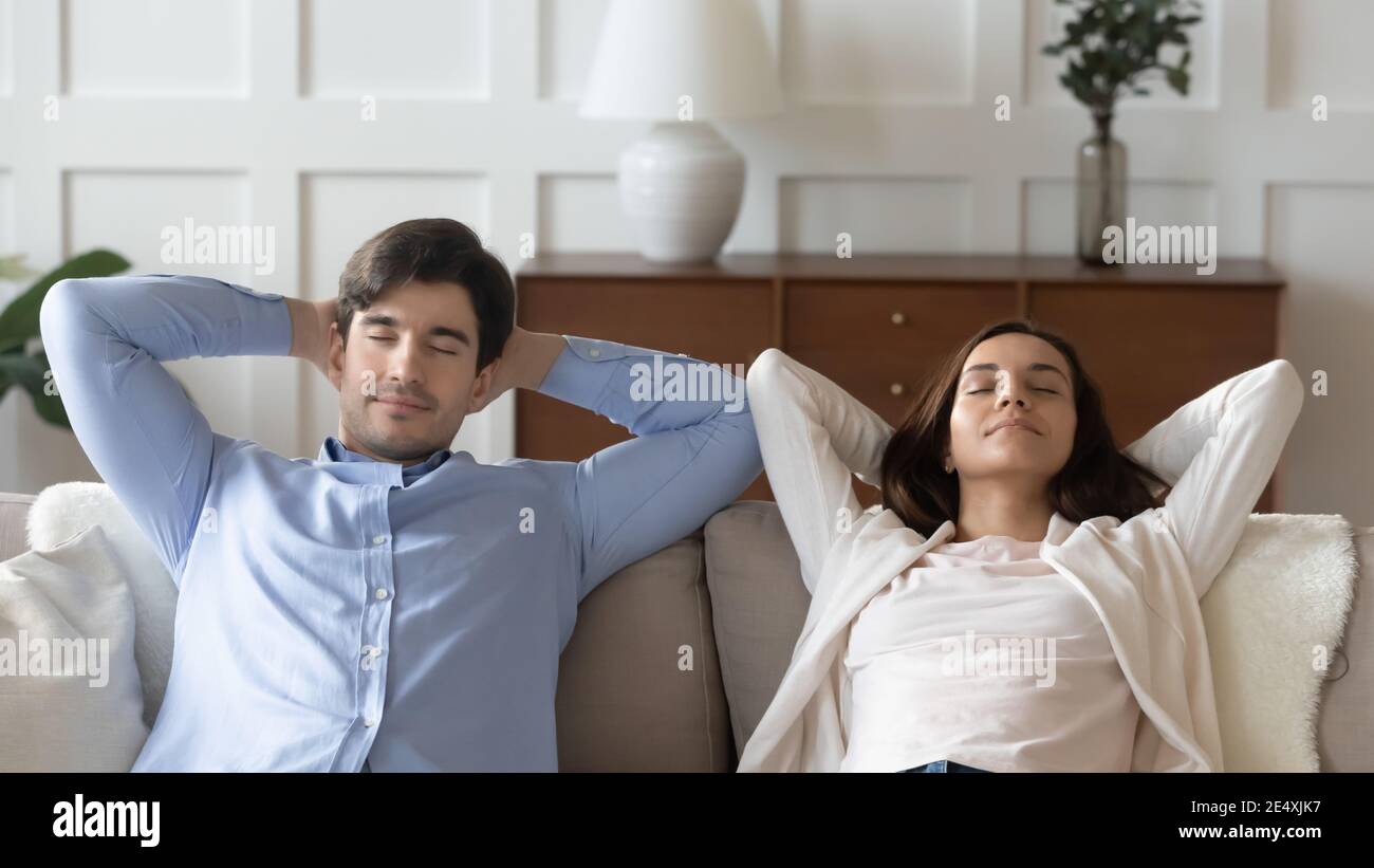 Cerca de la joven mujer y el hombre descansando juntos en el sofá Foto de stock