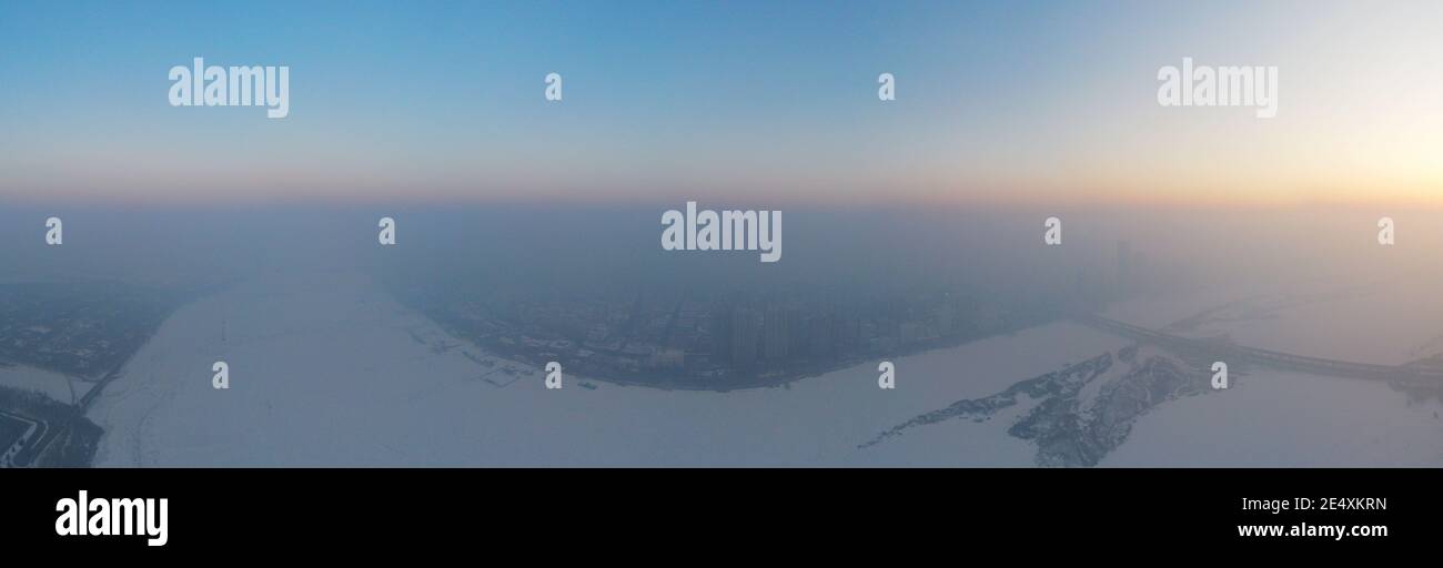 Una vista aérea de los edificios ubicados en el centro de la ciudad cubierta por una fuerte neblina en la ciudad de Harbin, noreste de China¯provincia de Heilongjiang, 24 de enero de 2021. * Foto de stock