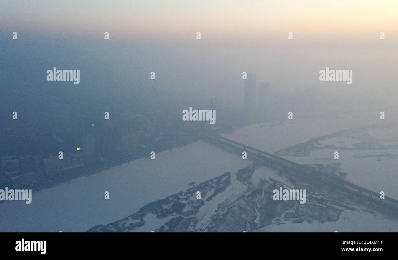 Una vista aérea de los edificios ubicados en el centro de la ciudad cubierta por una fuerte neblina en la ciudad de Harbin, noreste de China¯provincia de Heilongjiang, 24 de enero de 2021. * Foto de stock