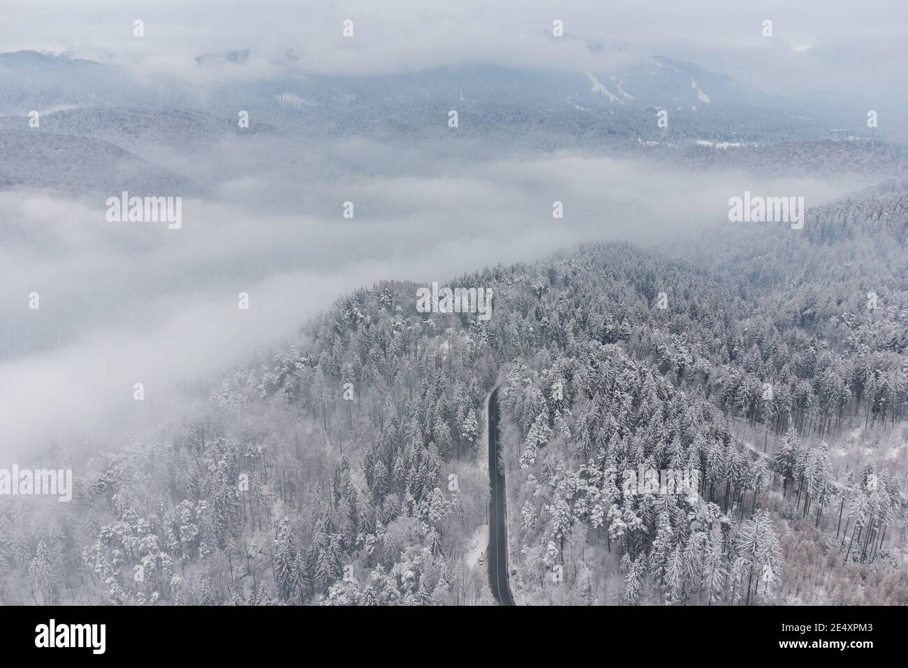 Vista aérea de invierno de la carretera de montaña curva, en Poiana Brasov Foto de stock