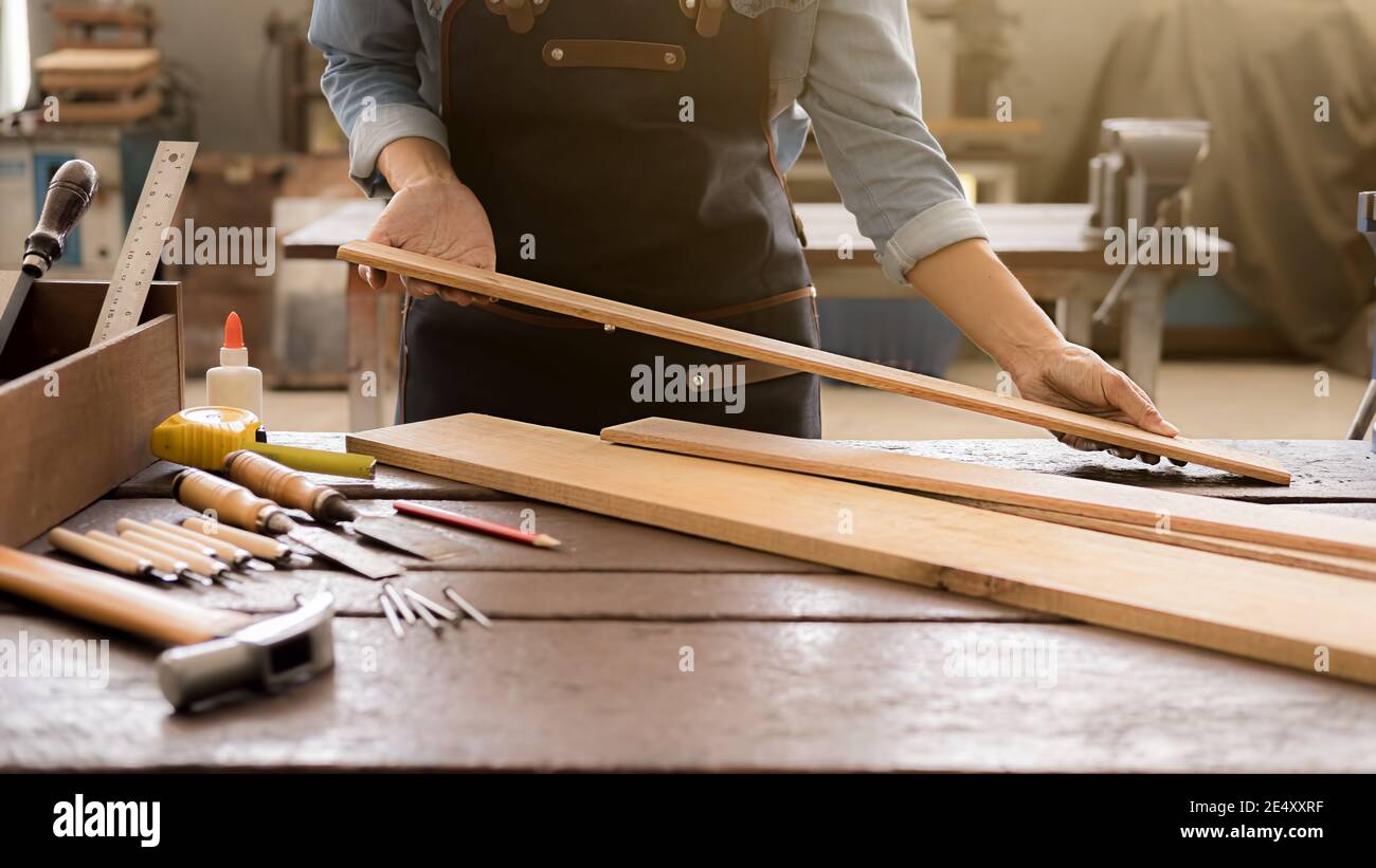 Carpintero trabajando con equipo en mesa de madera en carpintería. Mujer  trabaja en una tienda de carpintería Fotografía de stock - Alamy