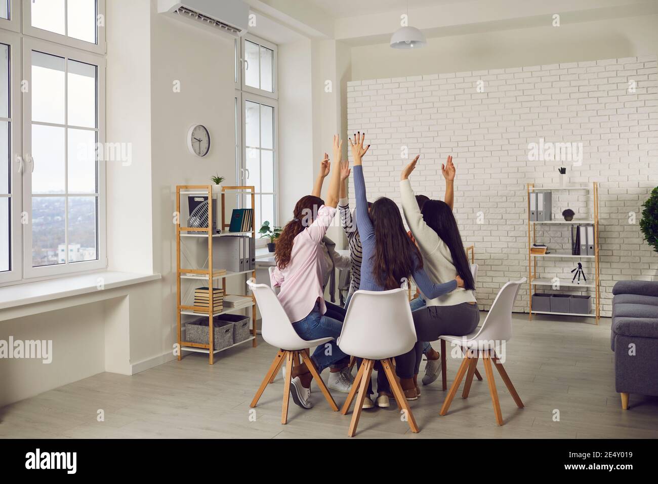 Equipo de mujeres alzando las manos dispuestas a participar nuevo proyecto o votar por una buena idea Foto de stock