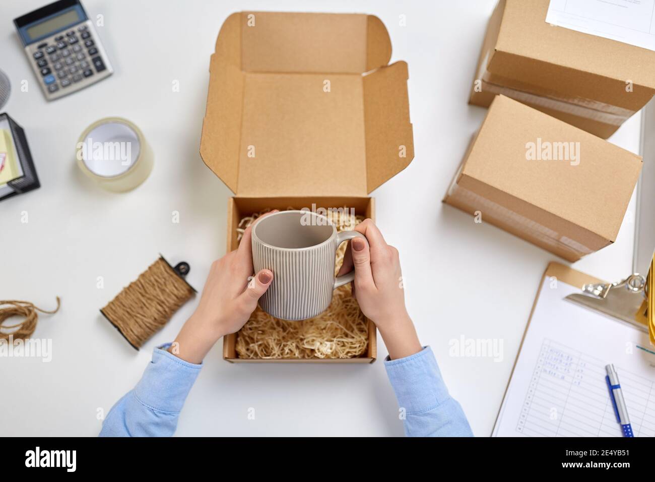manos de embalaje taza a la caja de paquetes en la oficina de correos  Fotografía de stock - Alamy