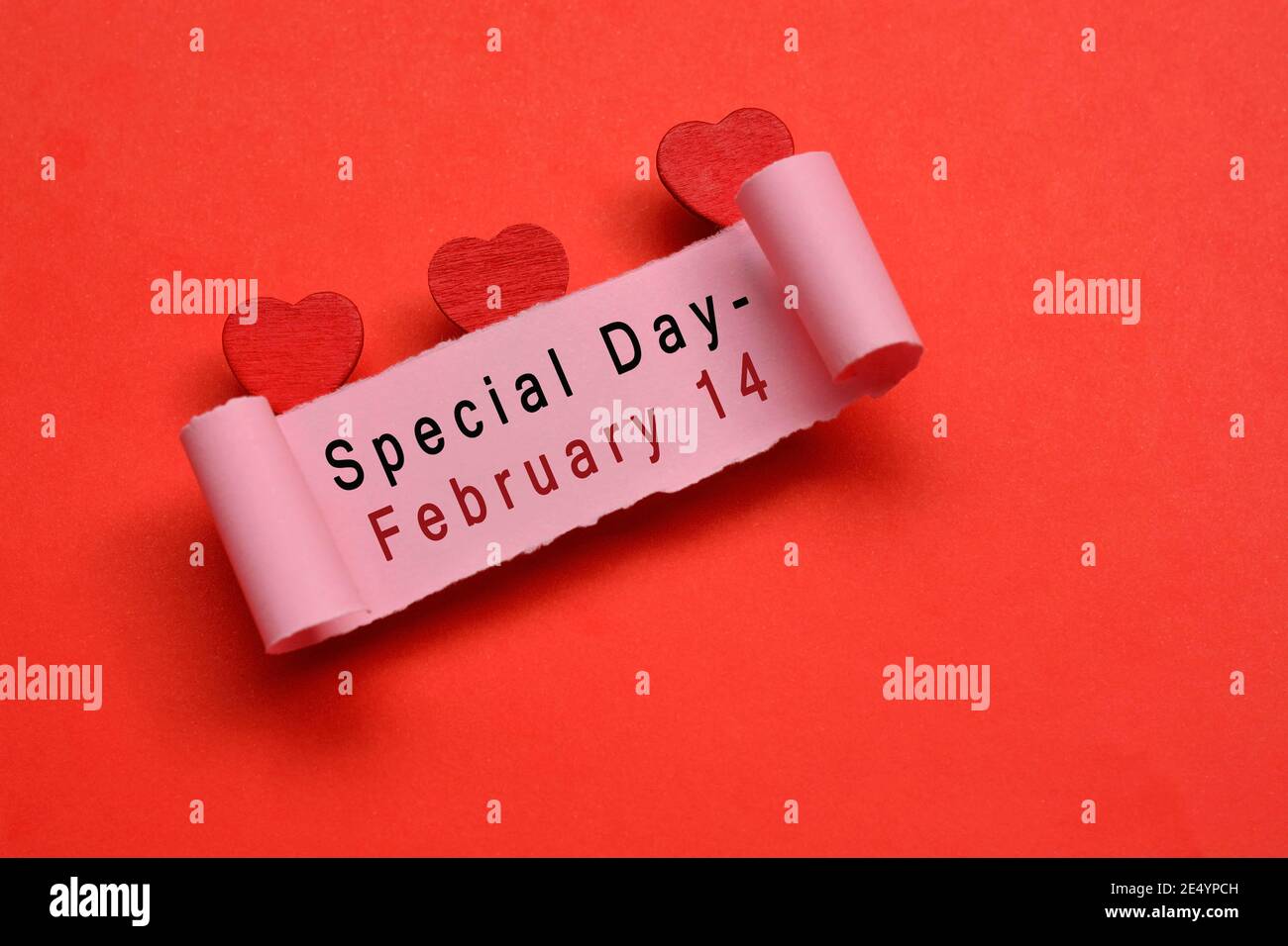 Día especial 14 de febrero etiqueta en papel rasgado con fondo de papel rojo. El día de San Valentín y el concepto de aniversario de boda Foto de stock