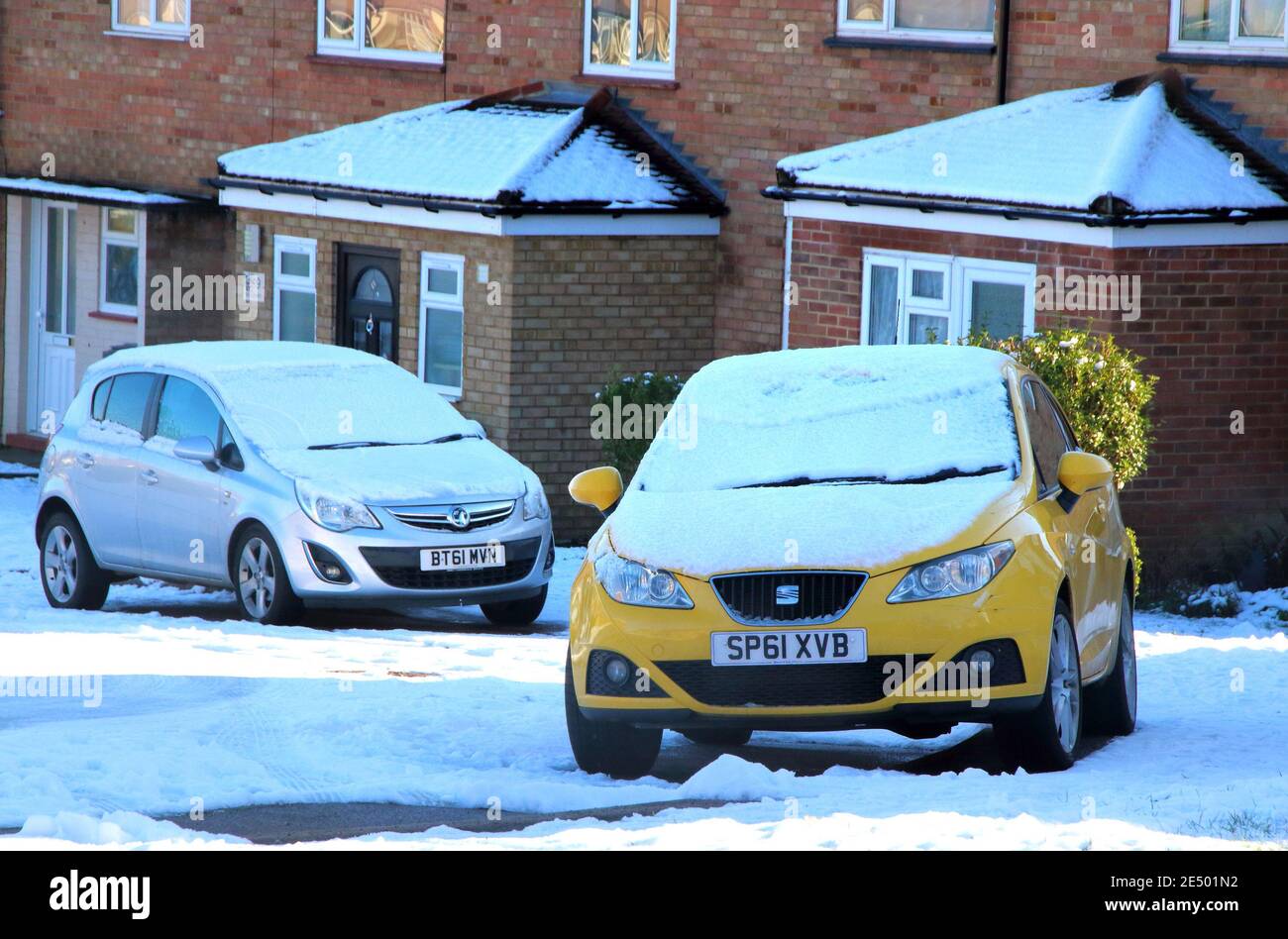 Bedford, Reino Unido. 25 de enero de 2021. Coches en una calle en la nieve con nieve habiendo caído sobre gran parte del sur y el este del país el domingo, el sol salió para el lunes. Blue Skies y el sol hicieron que las cosas más pequeñas paren pintorescas. Bedford tuvo su primera Nevada significativa en varios años. Bedford, Reino Unido Lunes 25 de enero de 2021 crédito: KEITH MAYHEW/Alamy Live News Foto de stock