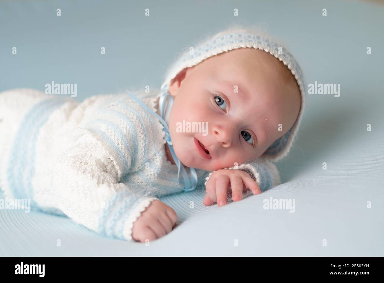 bebé feliz y sonriente con traje azul y blanco fondo azul Fotografía de  stock - Alamy
