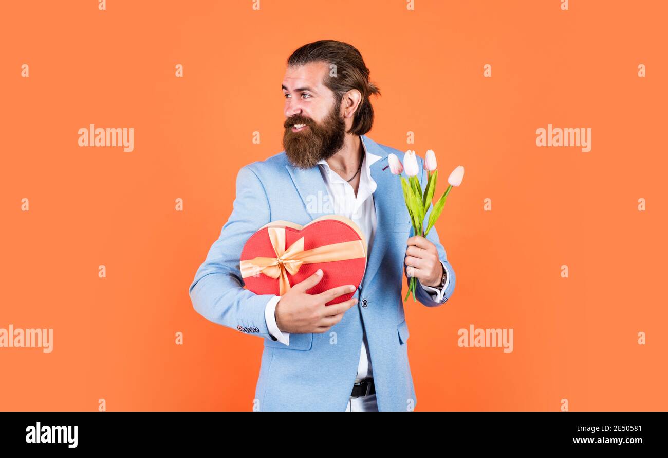 compra agradable. elegante hombre de negocios vestir elegante ropa para el evento formal. primavera presente. caballero verdadero con ramo. amor concepto de fecha. hombre barbudo en ropa de vestir con flores de compra agradable. elegante hombre de negocios vestir elegante ropa para el evento formal. primavera presente. caballero verdadero con ramo. amor concepto de fecha. hombre barbudo en ropa de vestir con flores de