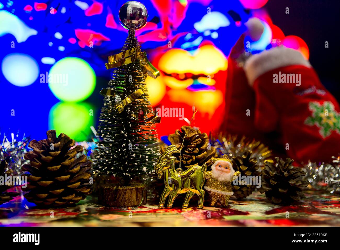 Little Santa se encuentra junto a un ciervo, esperando el nuevo año. Árbol de Navidad en miniatura. Adornos de Navidad Foto de stock