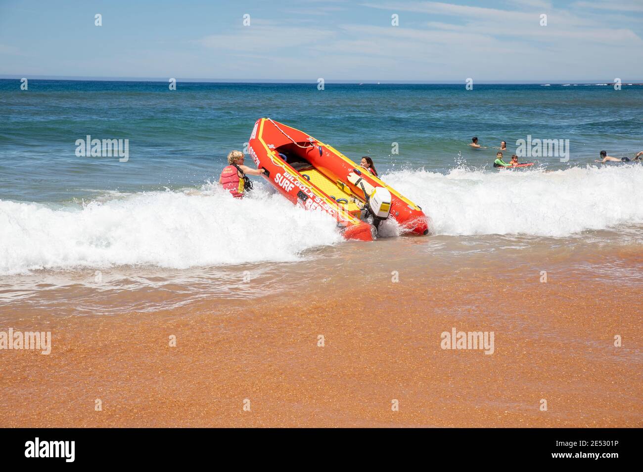 Los salvavidas de rescate de surf voluntarios lanzan rescate de surf zodiaco rojo inflable Barco en la playa de Bilgola en Sydney, Nueva Gales del Sur, Australia Foto de stock