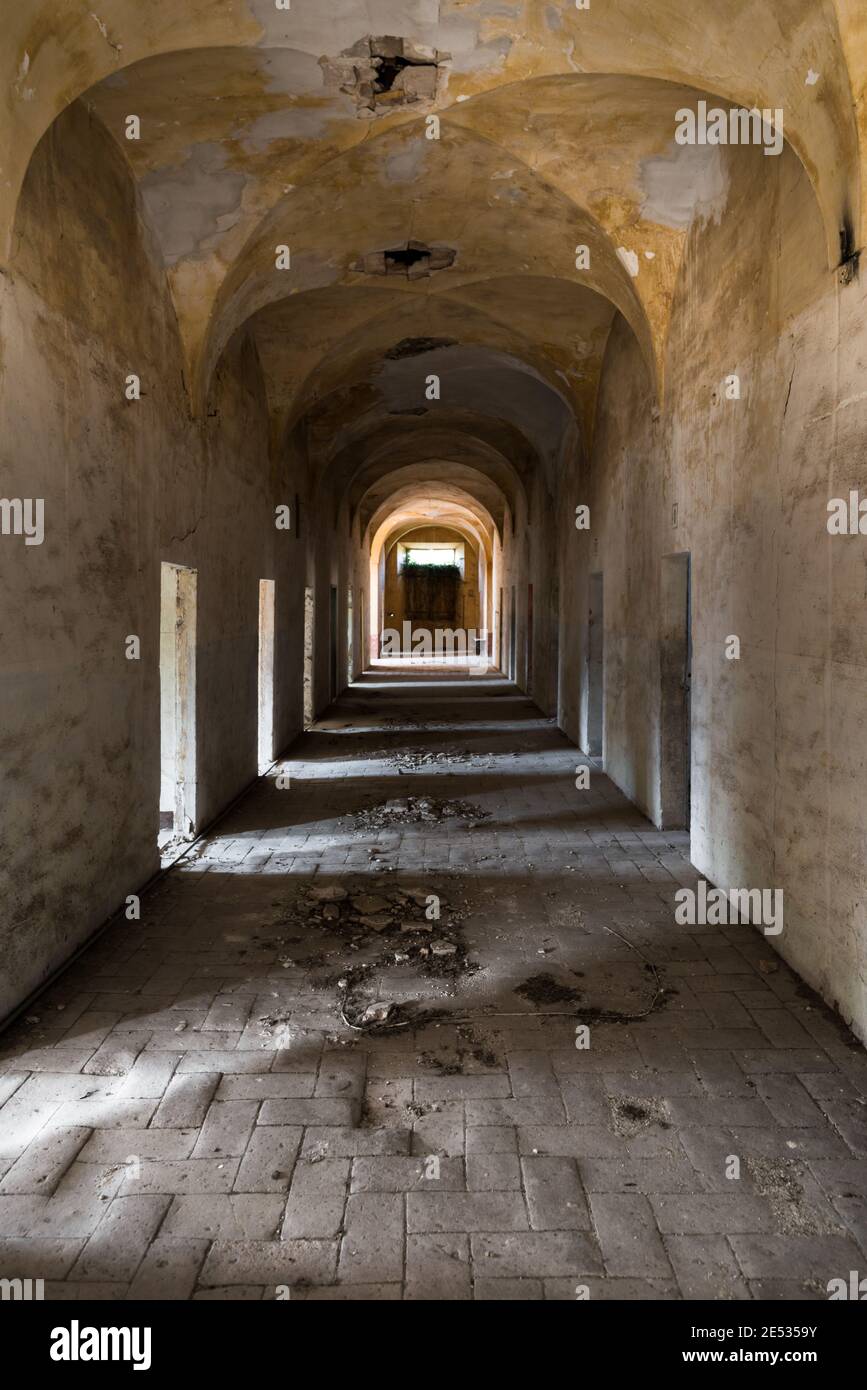 Vista simétrica de un gran ángulo de un pasillo en un antiguo Monasterio abandonado en el centro de Italia Foto de stock