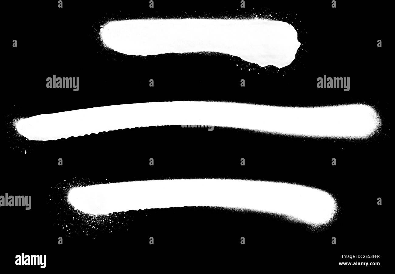 Primer plano de tres líneas blancas de pintura en aerosol, aisladas sobre fondo negro. Foto de stock
