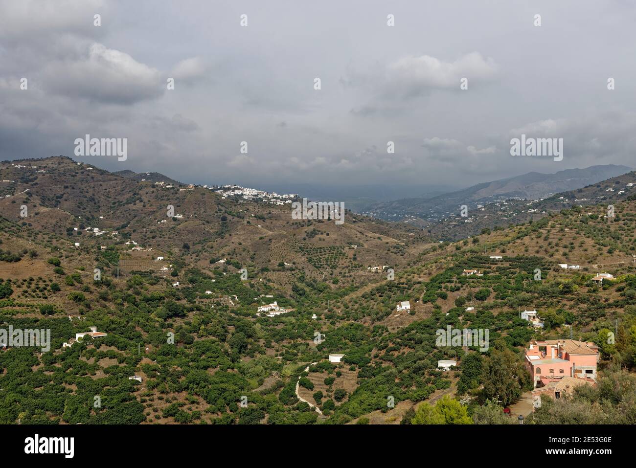 Pequeños pueblos de montaña, Fincas, Fincas y Villas salpican los diferentes lados ValleyÕs y montañosos de la España rural en Andalucía bajo cielos nublados. Foto de stock