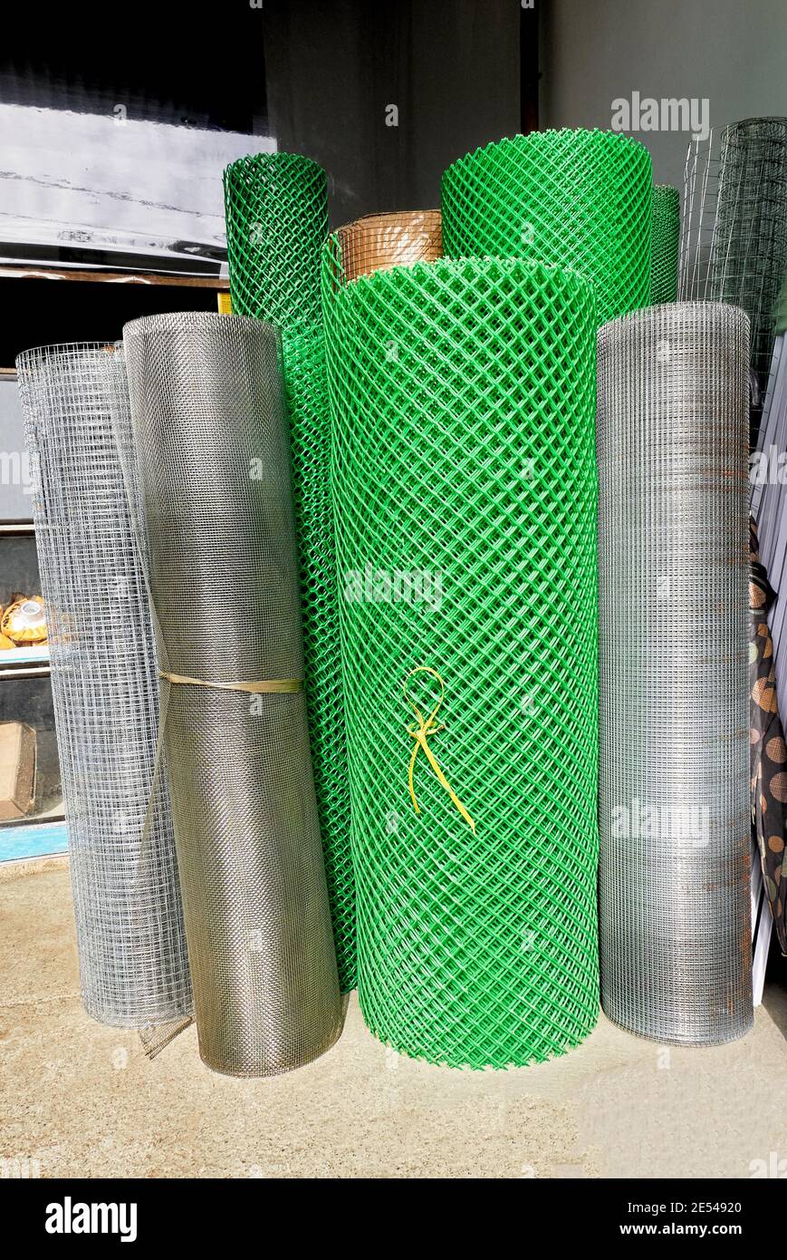 Matriz de rollos de metal y plástico verde de malla de alambre utilizada en  la industria de la construcción para la venta en una ferretería en  Filipinas, Asia Fotografía de stock -