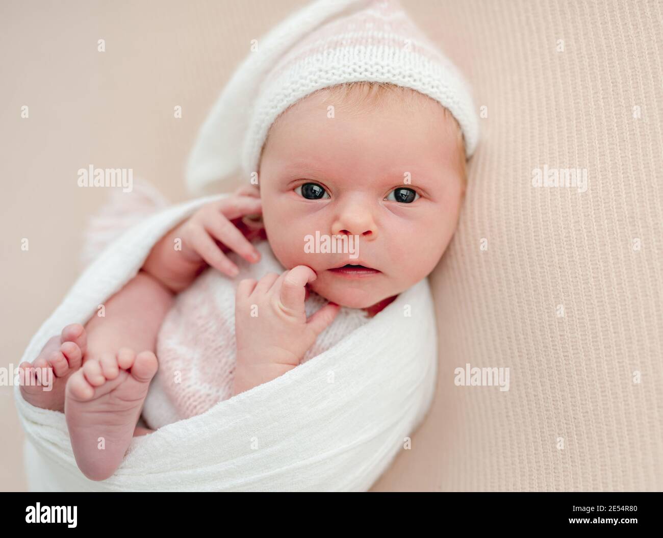 Recién nacido sin dormir en traje blanco y sombrero Foto de stock