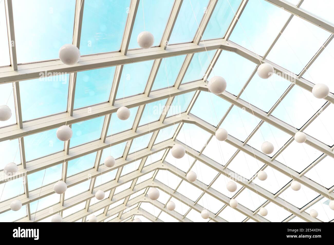 Techo moderno y transparente en interior futurista con arcos blancos en perspectiva. Lámparas esférico blancas. Foto de stock