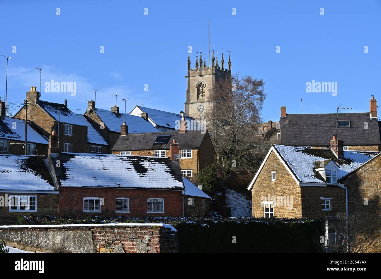 Vista de la iglesia parroquial de San Pedro en el north Oxfordshire pueblo de Hook Norton después de una Nevada día anterior Foto de stock