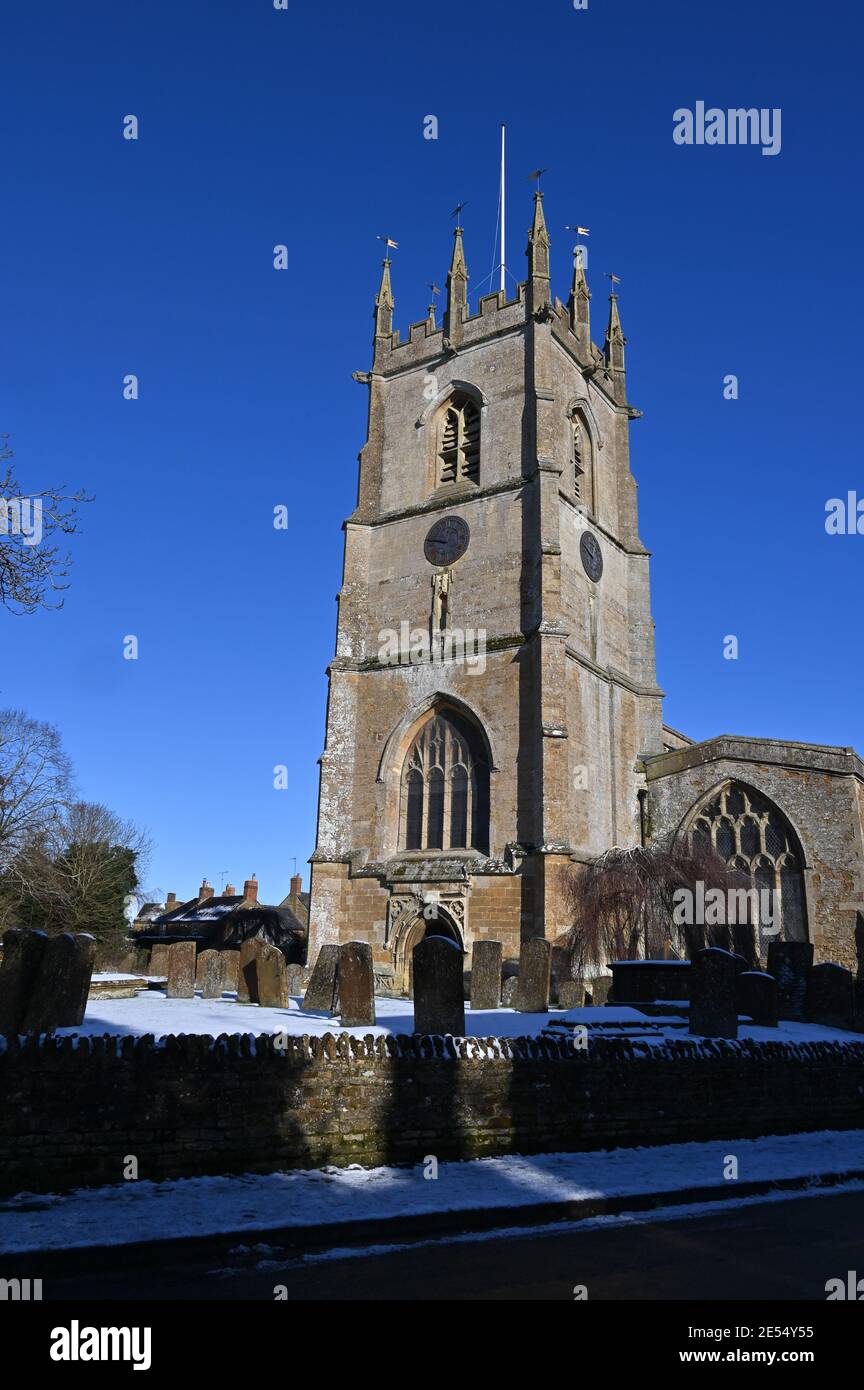 Vista de la iglesia parroquial de San Pedro en el north Oxfordshire pueblo de Hook Norton después de una Nevada día anterior Foto de stock